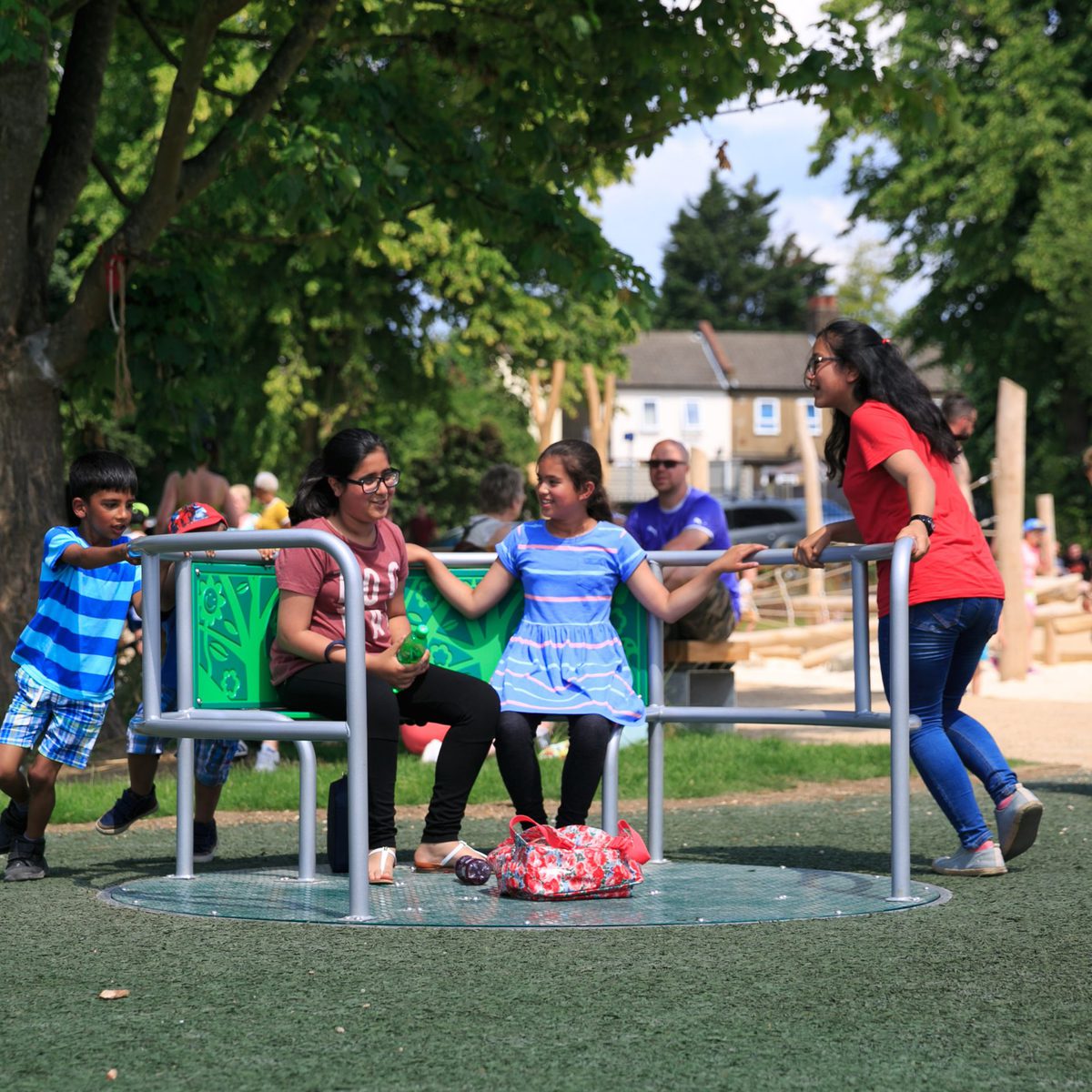 Diverse group of children playing on a Wildlife Whirl from Inclusive Play: an inclusive roundabout
